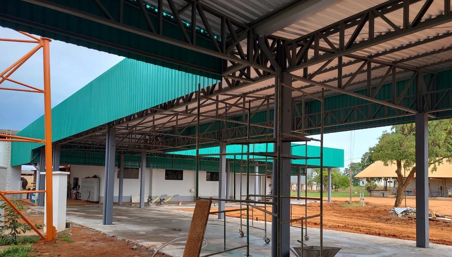 Vista interna de cobertura com pilares e treliças