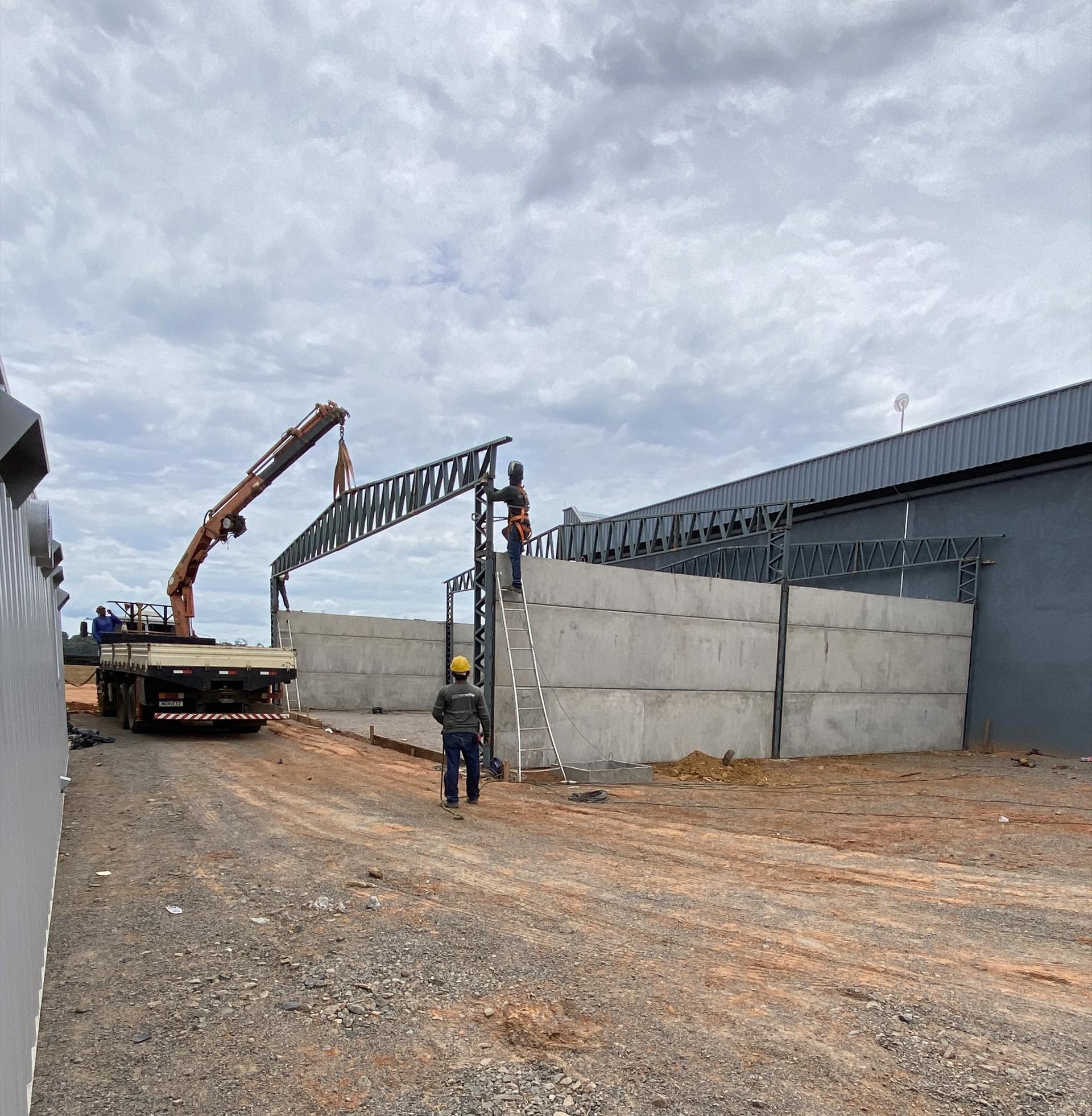 Painéis de concreto e treliças de cobertura sendo montados