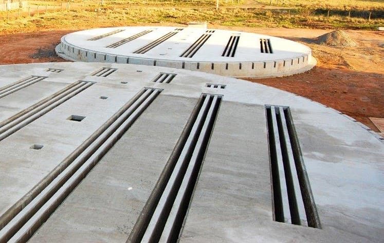 Elementos circulares pré-moldados dispostos em uma obra de armazenagem