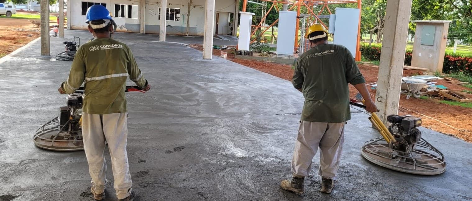 Equipe executando o acabamento de um piso industrial de concreto