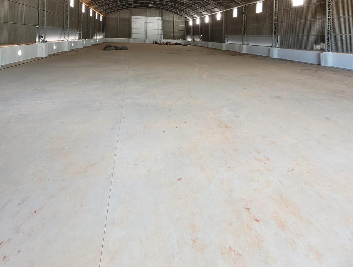 Interior de galpão industrial com grande vão livre e piso de concreto